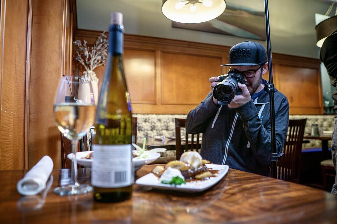 Kyle photographing a wine and dessert restaurant scene