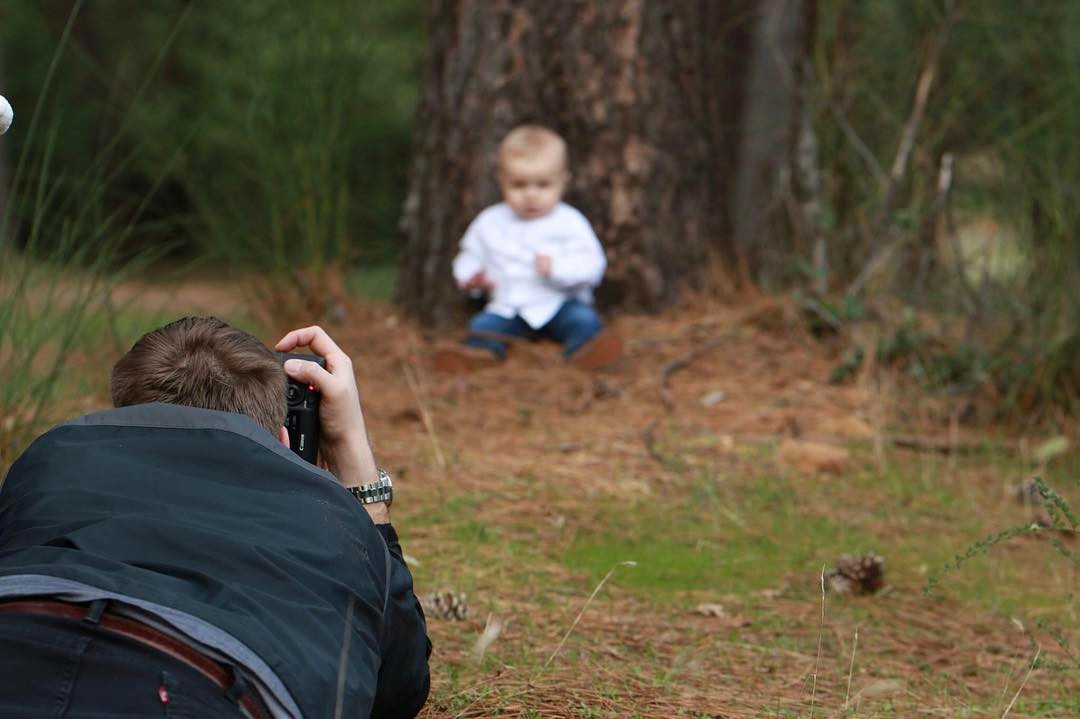 Kyle low to the ground shooting a child portrait in the woods