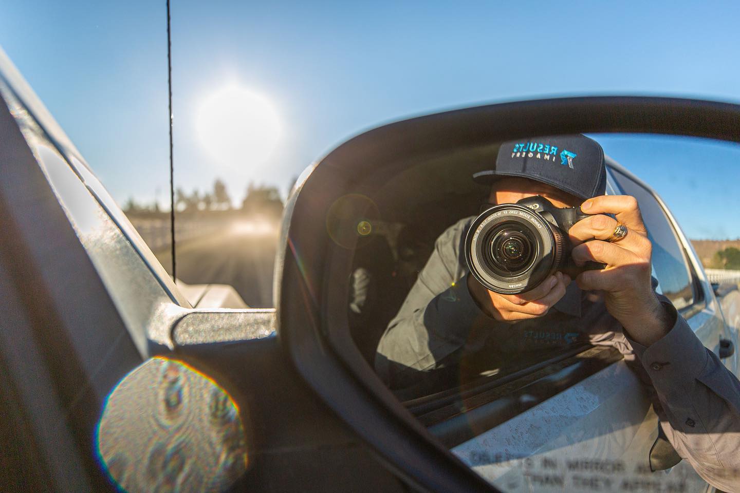 Kyle in a Results Imagery hat reflected in a side mirror