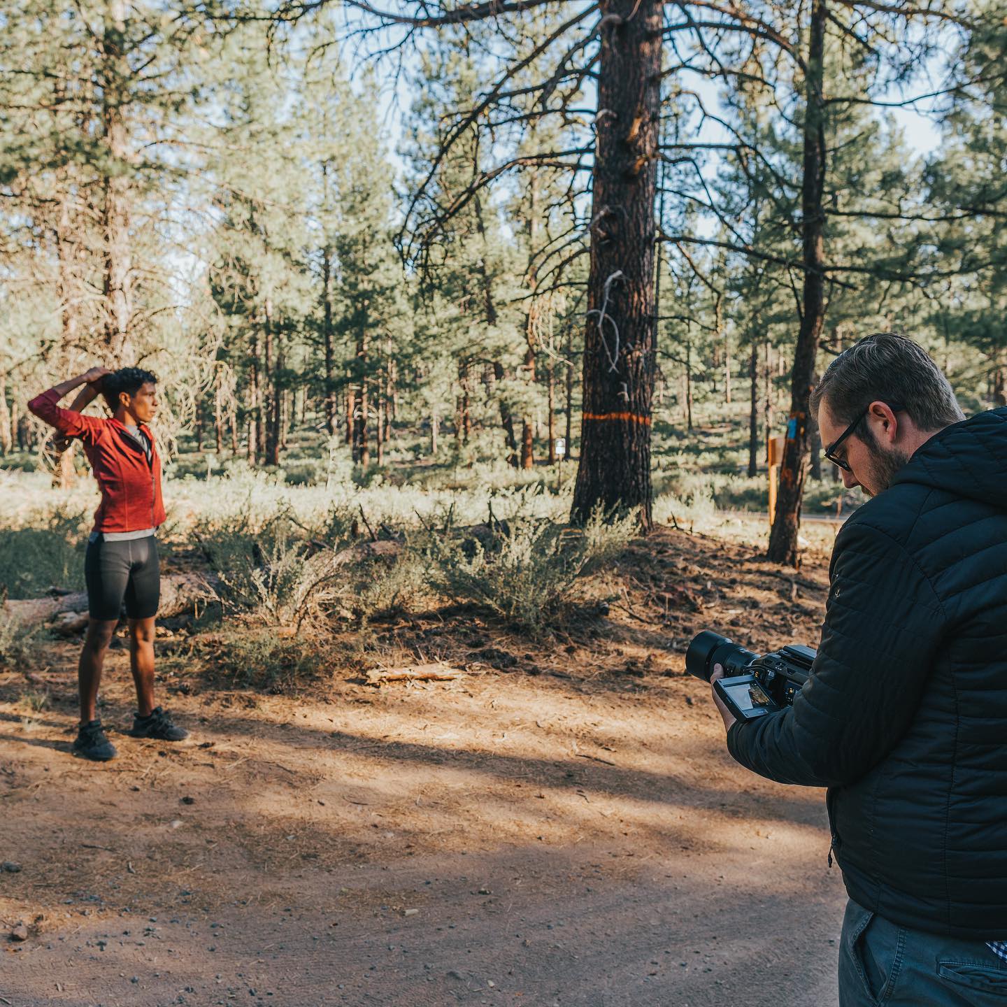 Kyle shooting a runner in a ponderosa pine forest at golden hour