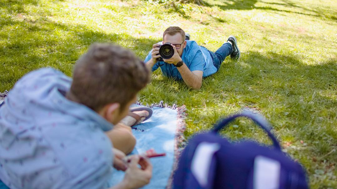 Kyle laying in the grass shooting a lifestyle portrait